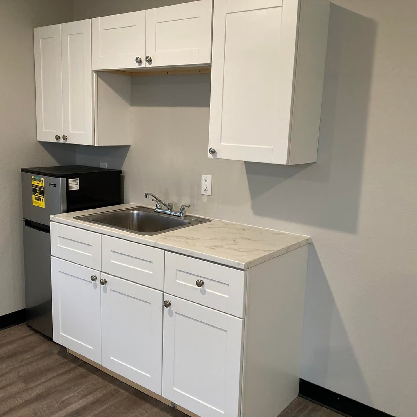 Apartment kitchenette with white cabinets at The Meadows